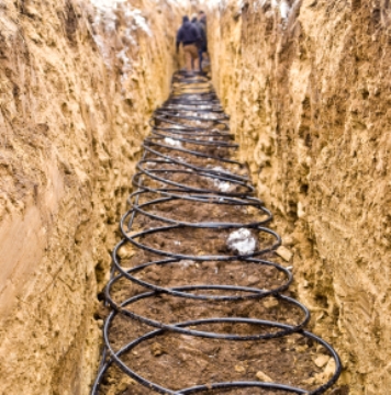 Workers install a closed loop geothermal system